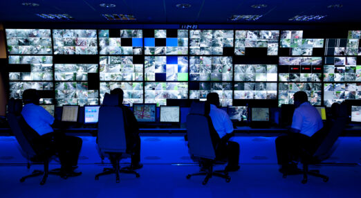 Operators sat in front of a bank of screens displaying hundreds of CCTV images
