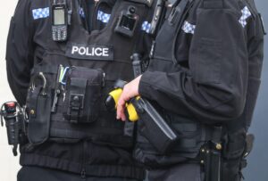 Uk Police officer wearing a tactical vest including a tazer gun, and body camera.