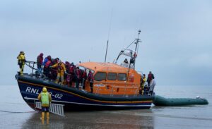 File photo dated 20/11/21 of a group of people thought to be migrants are brought in to Dungeness, Kent, by the RNLI following a small boat incident in the Channel. The Government should scrap plans to turn back migrant boats at sea because they "endanger