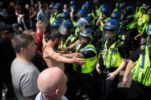 Manchester, UK. 03rd Aug, 2024. A anti-immigration supporter confronts riot police after scuffles broke out in Piccadilly Gardens. Earlier this week, protests and riots erupted across the country after a horrific knife attack in Southport, which saw a 17-